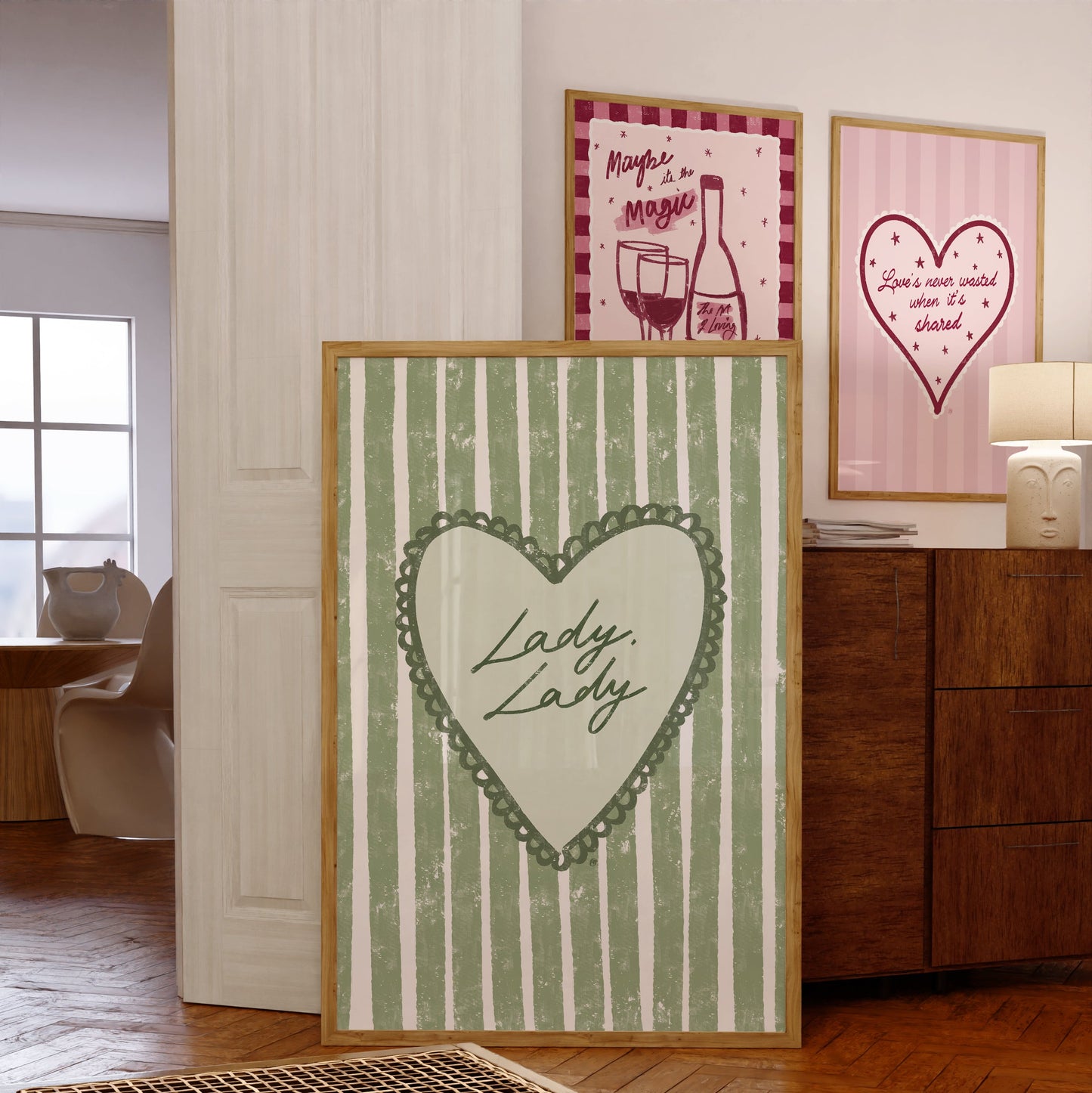 three framed artworks with a heart design and lyrics in a room setting.