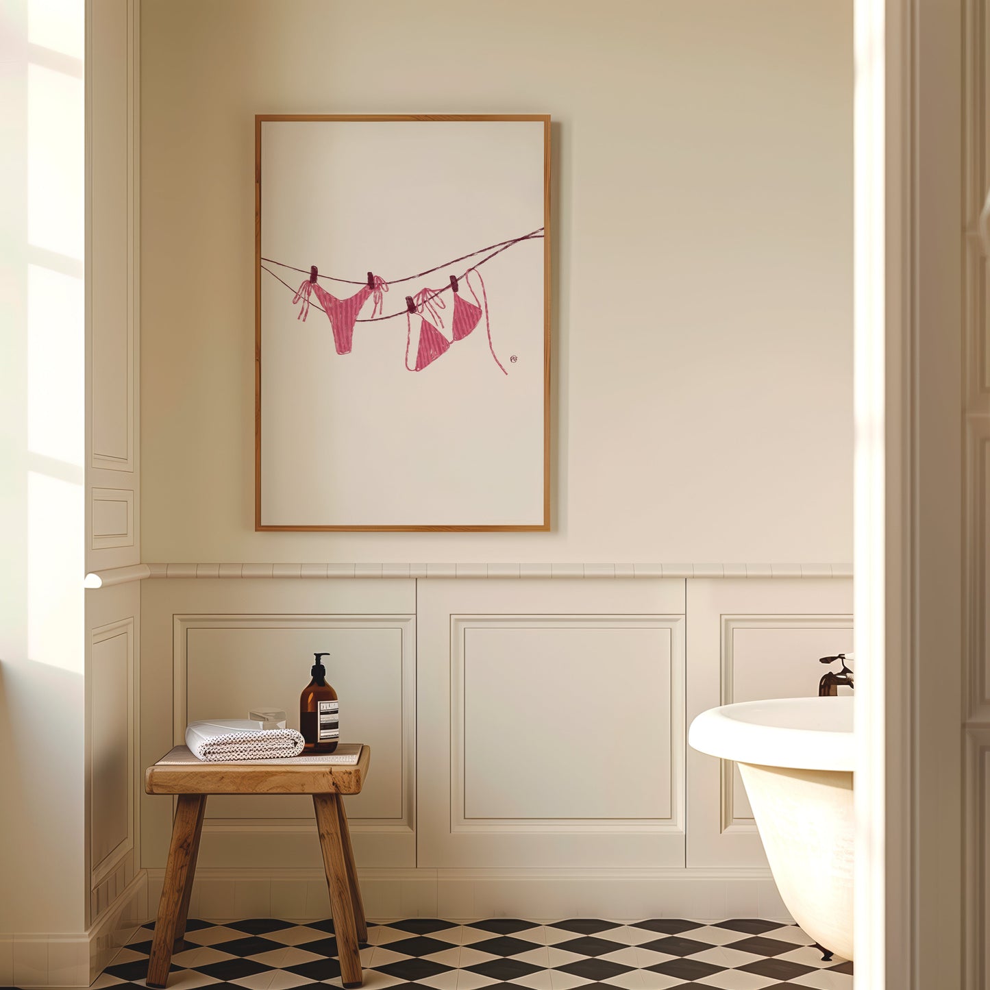 Bathroom interior with a framed PINK BIKINI artwork on the wall, wooden stool, and bathtub.