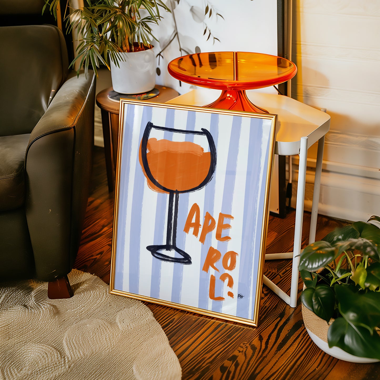 Framed artwork with a glass design and 'Aperol?' text in a living room setting.