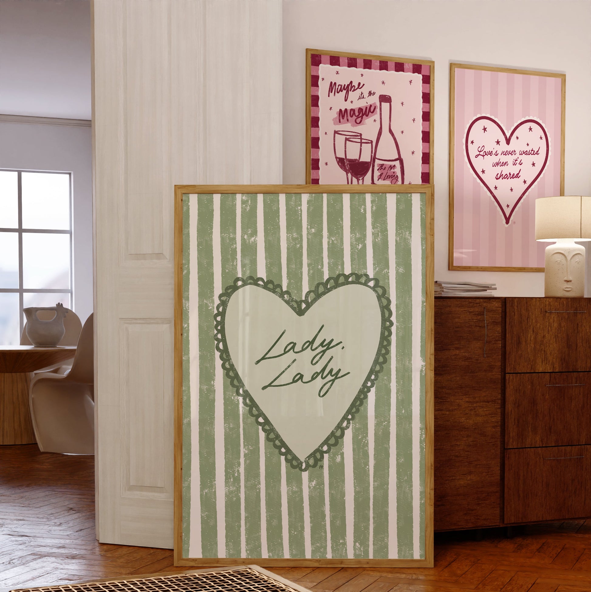 three framed artworks with a heart design and lyrics in a room setting.