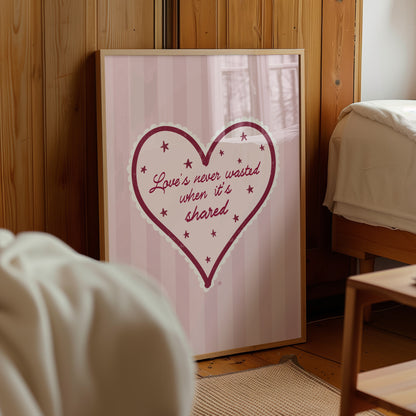 Framed artwork with a heart design and text on a wall in a room.