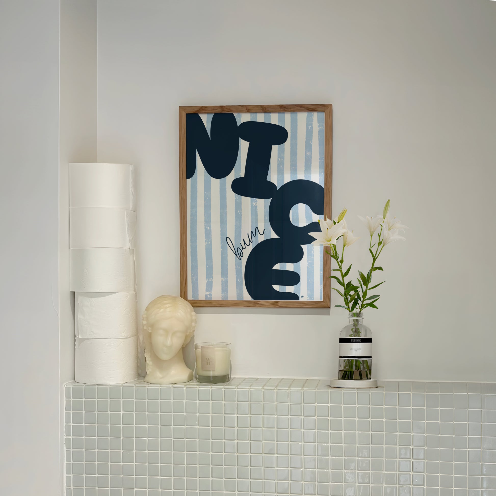Decorative wall art with 'NICE BUM' text in a bathroom setting