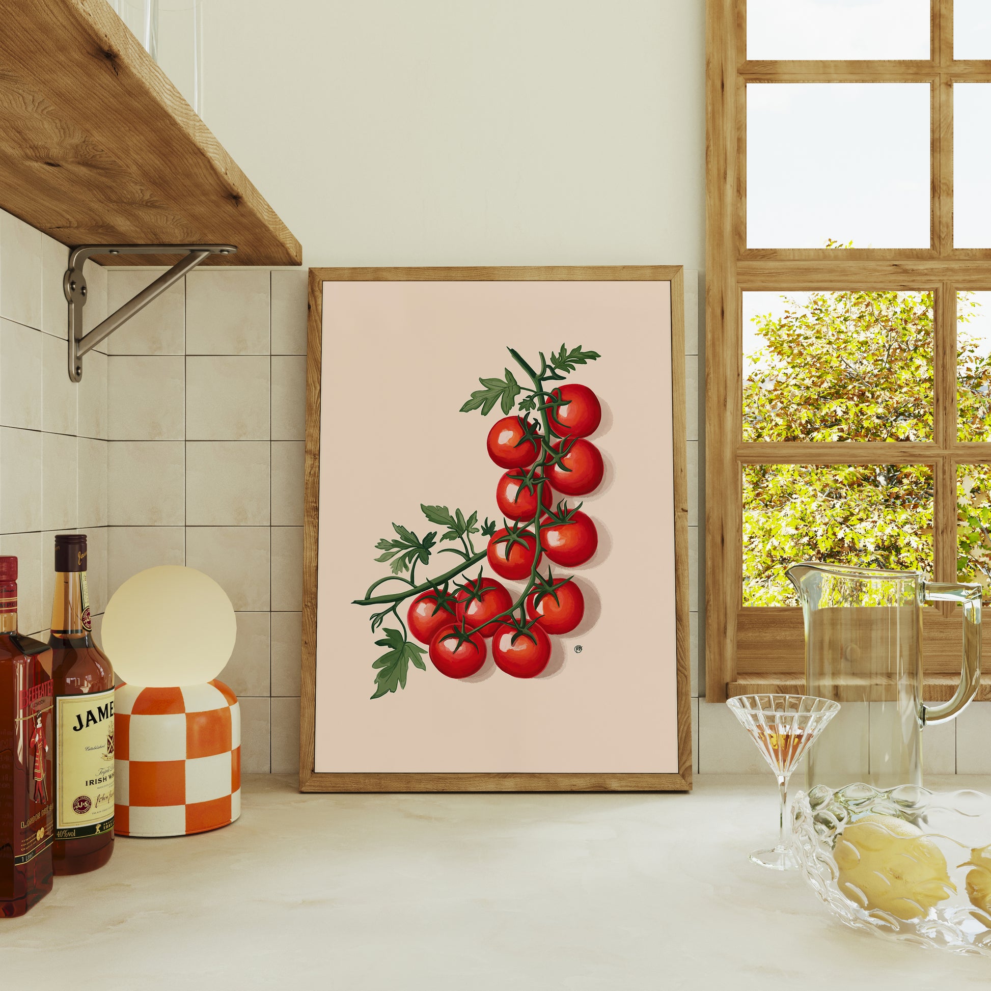 Framed artwork of tomatoes on a kitchen counter with a window in the background