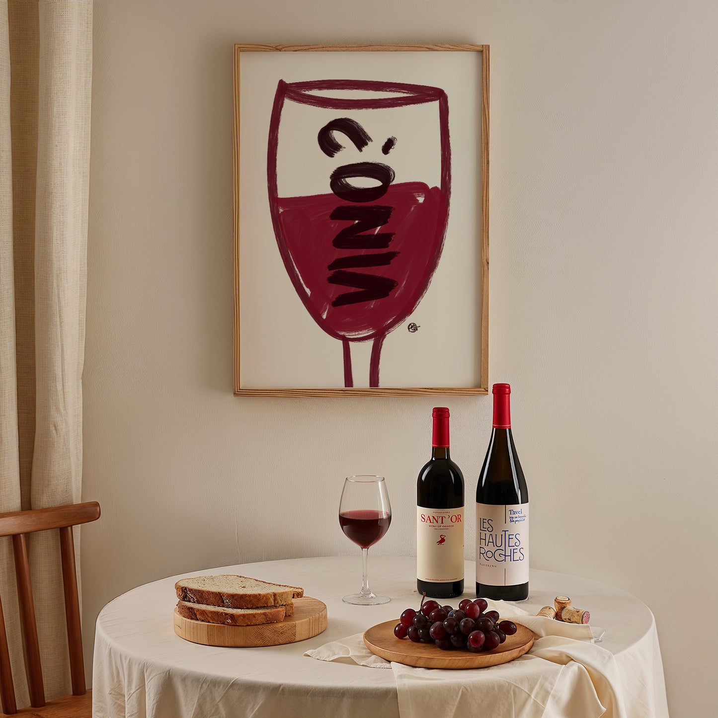 Wine-themed decor with bottles, glasses, and grapes on a table, framed artwork in the background.