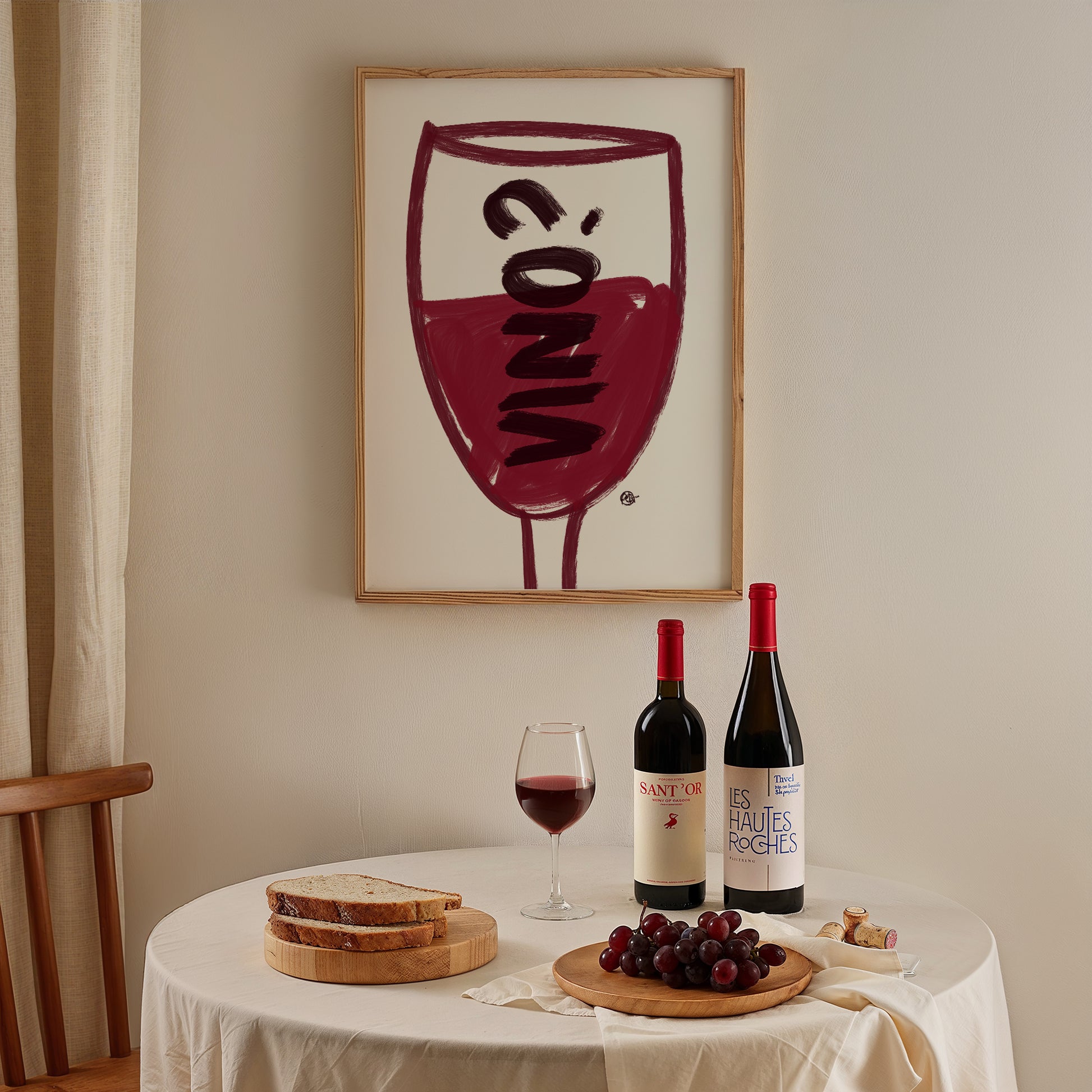 Wine-themed decor with bottles, glasses, and grapes on a table, framed artwork in the background.