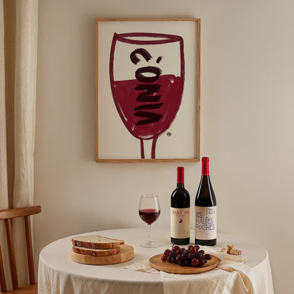 Wine-themed decor with bottles, glasses, and grapes on a table, framed artwork in the background.